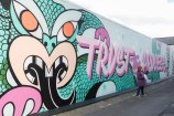 Large mural with pink and green with the words Trust the process as part of the mural.