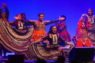 Performers dance on stage in traditional clothing as part of the Diwali festival.