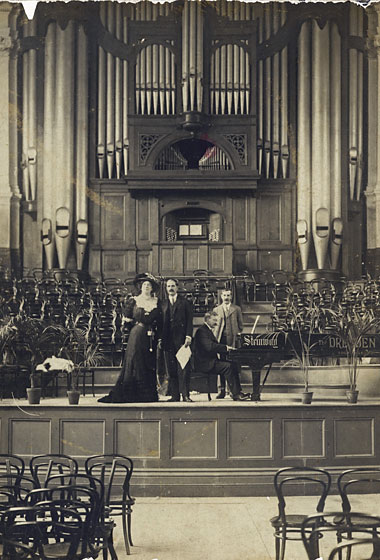 Performers on the stage in Wellington Town Hall, with the organ behind them.