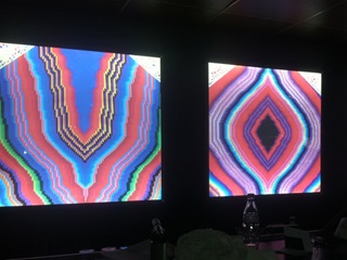 Colourful patters displayed on screens in a dark room.