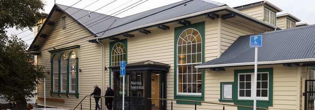 The front of the Newtown Community and Cultural Centre, a large wooden building with large windows.