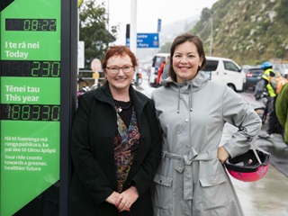 A photo of Deputy Mayor Sarah Free and Associate Minister of Transport Julie Anne Genter next to the new bike counter visual display unit on the Hutt Road bike and walking paths. The display unit is green and displays a count for the day and year.