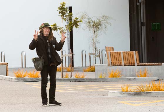 Person standing in Wellington city centre, making the victory sign with both hands.