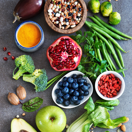 Image of fresh produce, including avocado, beans and blueberries, spread across a table.