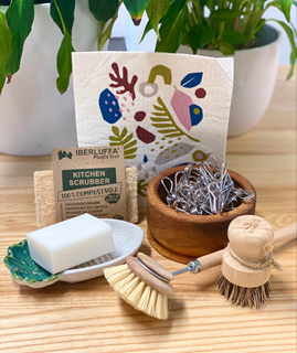 A range of plastic-free household items including eco dish brush, metal pegs, soap bar and kitchen cloths.