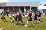 Children and adults on a grassy field enjoying the rakau challenge with sticks at the Waitohi first birthday community day.