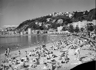 Black and white photo of people sunbathing on Oriental Bay beach. 