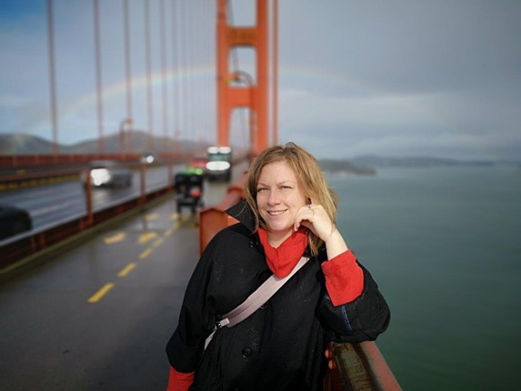 Crystal Filep, from Wellington City Council’s Urban Design team, standing on the red Golden Gate bridge in San Francisco with a rainbow behind.