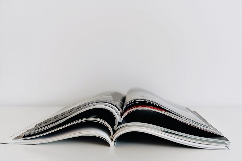 A stack of five open magazines on a white background.
