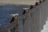 A close-up of a new fence with ocean behind at Kio Bay.