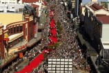 A birds eye view looking down Courtenay Place towards the Embassy Theatre, with crowds of people and the red carpet laid out down the main road for the opening of Lord of the Rings.