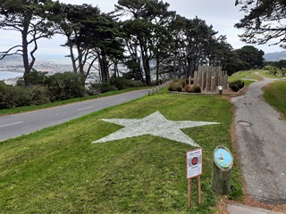 A photograph of the grassy park at the top of Mount Victoria with a large white star painted onto the lawn.
