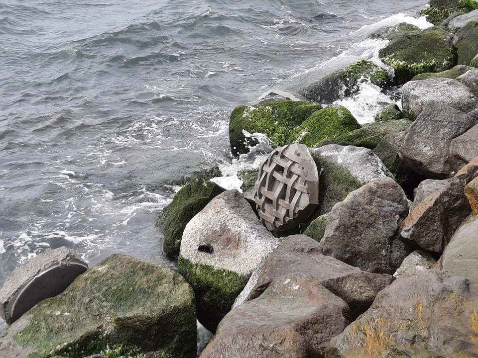 Landscape image of kete tile installed on rocks in the harbour