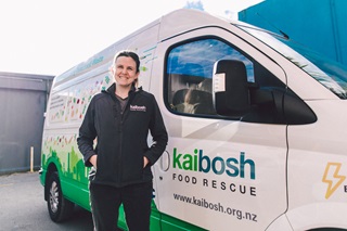 A staff member from Kaibosh standing beside their food rescue truck.