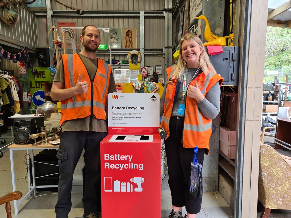 Staff at Tip Shop display new used battery recycling drop-off station
