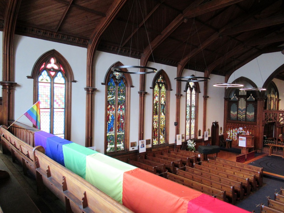 Interior of St Peter's Church with rainbow flags