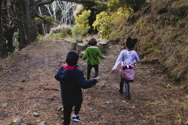 Three kids running down a path.