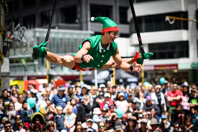 A Very Welly Christmas circus performer does aerial tricks in front of large crowd on Lambton Quay