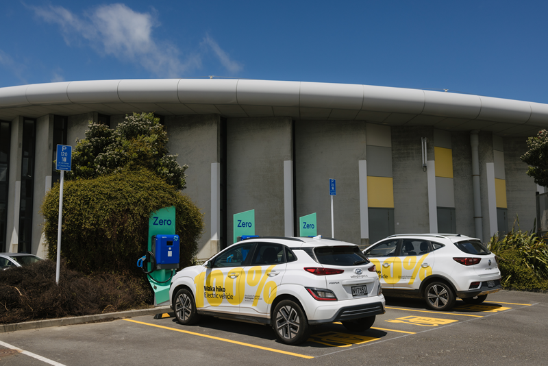Vehicles charging with new EV chargers outside Ākau Tangi sports facility. Vehicles charging with new EV chargers outside Ākau Tangi sports facility.