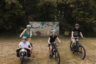 Family cycling together on e-bikes and a cargo bike.