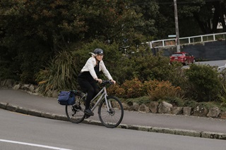 Woman cycling down a hill.