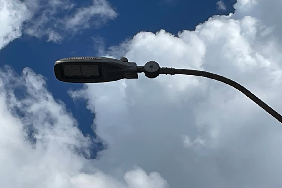 Street light with sky and clouds in background.