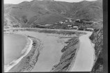 Houghton Bay in 1926 with beach in foreground and a few small wooden houses in background.