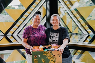 Two women at the Strathmore Community Centre holding a box of food.