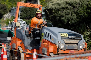 Man sitting on a tractor as part of the roadworks crew.