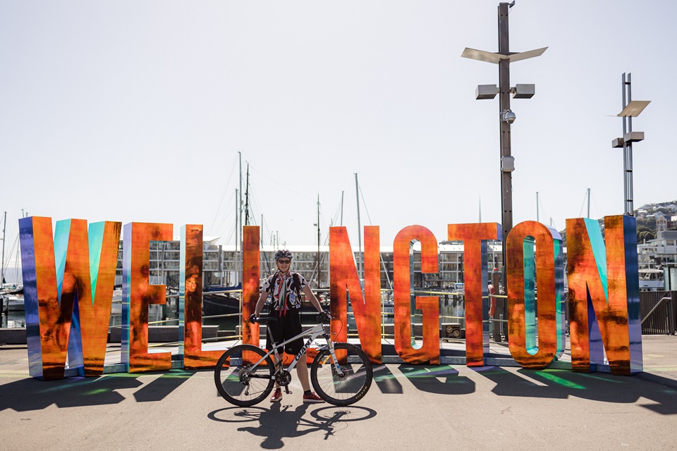 Cyclist Sarah Bennett in front of the Wellington sign