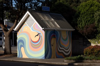 Cute little building with a mural painted on it.