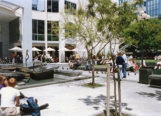 Archive image of an urban park with people sitting on benches.