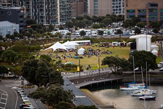 Waitangi park with a tent set up and cars and boats in the foreground.