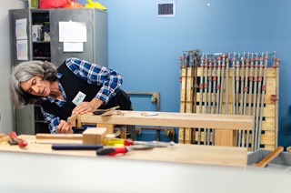 Volunteer doing woodworks at a table. 