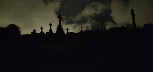 Photo of Karori Cemetery grave headstones at dusk with clouds in background