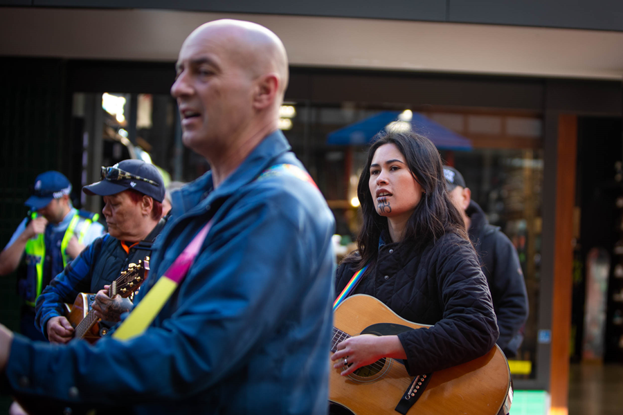 A group with guitars singing.