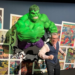 Marvel curator Ben standing infront of the Hulk coming out of the wall.
