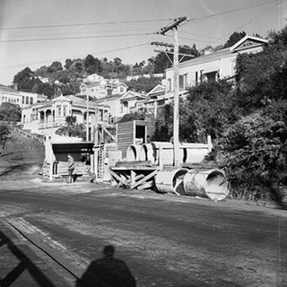 Possible repairs to drains in progress. Wellington City Council worksheds, workmen, residential area.