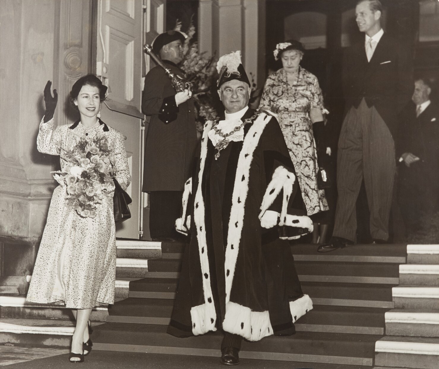 Image of Queen Elizabeth II with Sir Robert Macalister, Mayor, descending main entrance stairs of Town Hall