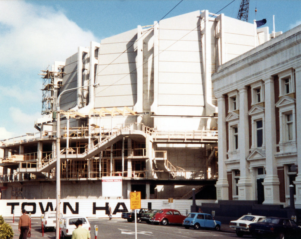 The side of a white building with hoardings in front that read 'Town Hall'.