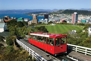 Cable car going up the hill with the city in the background.