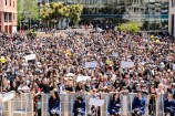 Crowd of people in Civic Square standing behind a barricade.