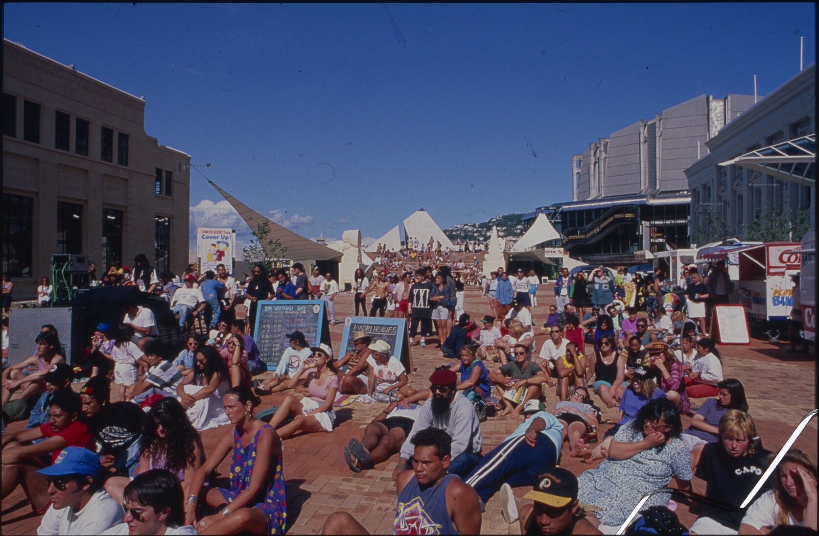 People sitting on the ground in civic square.