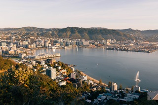 The Wellington harbour surrounded by city buildings on a sunny day.