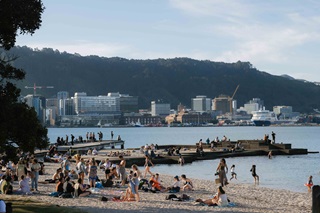 Freyberg Beach with people lounging on the sand.