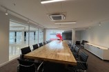 Board room with black leather chairs surrounding a wooden table.