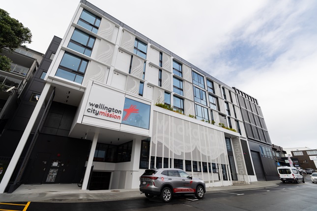Large building with multiple stories and a car parked out front.