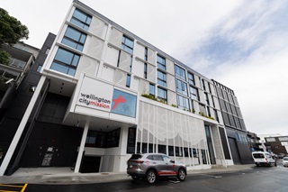 Large building with multiple stories and a car parked out front.