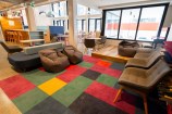 Lounge furniture sitting on top of coloured checkered carpet.