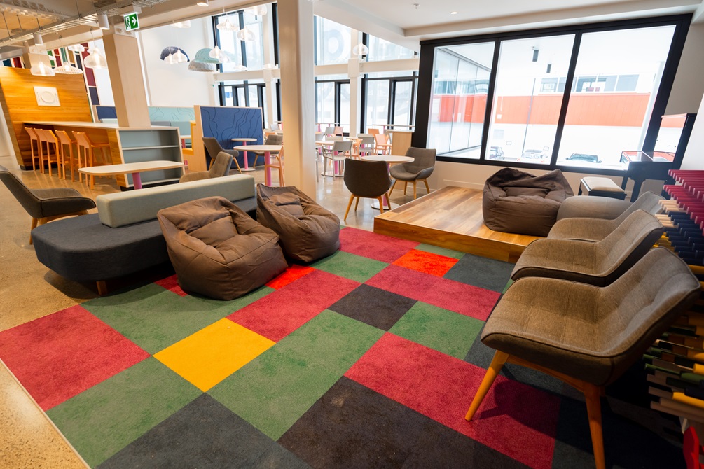 Lounge furniture sitting on top of coloured checkered carpet.